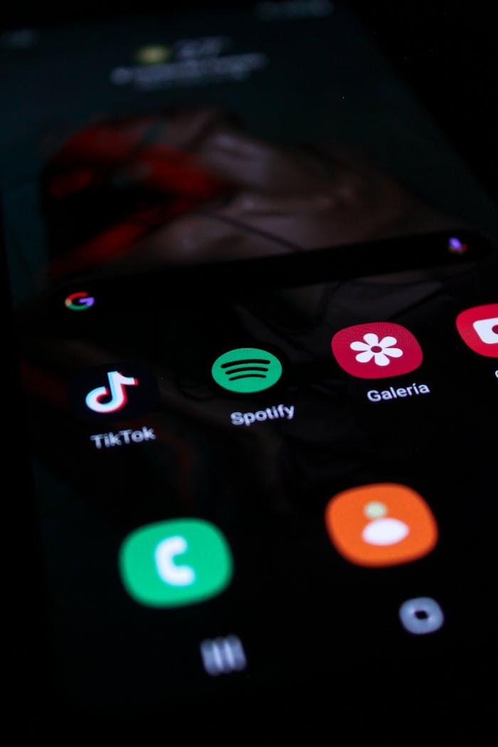 Services Vertical shot of a smartphone screen showing popular app icons like TikTok and Spotify.